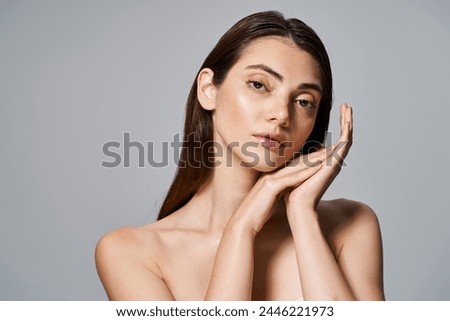 Young caucasian woman with brunette hair posing with hands on face, exuding introspection and grace.