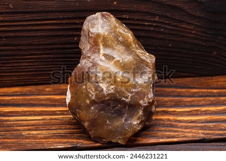 Stone scraper made of red-yellow chalcedony, Stone Age tool Royalty-Free Stock Photo #2446231221