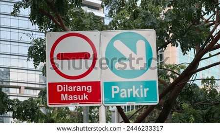 Two traffic signs in a city setting. No entry sign and parking sign, these universal traffic symbols convey important messages to drivers and pedestrians, regardless of language or location.