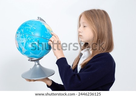 Schoolgirl holding globe. Back to school concept. High quality photo