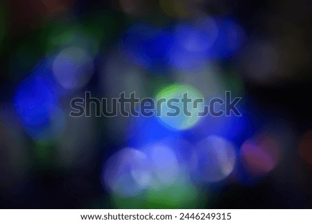 Defocused neon light. Overlay of light highlights. Futuristic abstract LED illumination. Blur of neon colors on dark abstract background