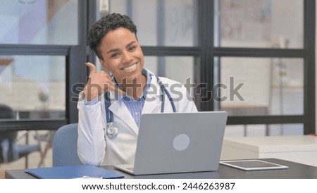 Call me Gesture by Mixed Race Female Doctor While using Laptop