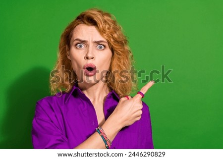 Photo portrait of attractive young girl scared point empty space dressed stylish violet garment isolated on green color background