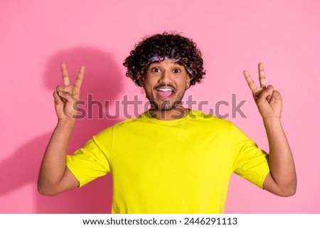 Photo of positive crazy good mood man wear trendy yellow clothes v-sign symbol isolated on pink color background