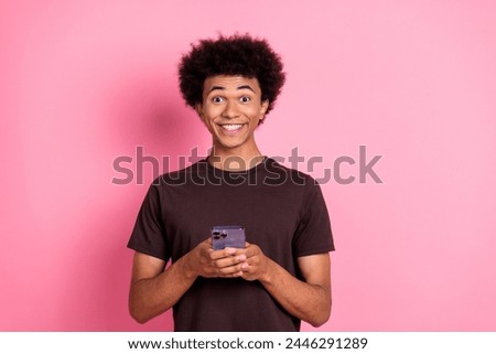 Photo of young wavy hair chevelure guy in brown t shirt toothy beaming smile when realize win esport bet isolated on pink color background
