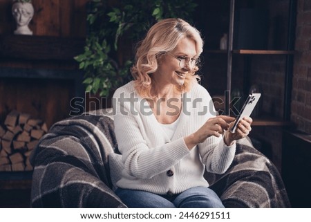 Photo portrait of lovely retired woman hold device reading wear casual clothes cozy home interior living room in brown warm color