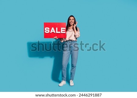 Full size photo of impressed ecstatic woman dressed silk shirt jeans hold sale board astonished staring isolated on blue color background