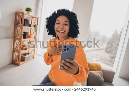 Photo portrait of lovely young lady video call talk laughing dressed casual orange clothes cozy day light home interior living room