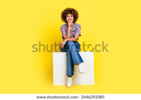 Full length photo of cheerful thoughtful lady dressed print shirt sitting white platform arm chin isolated yellow color background Royalty-Free Stock Photo #2446292085