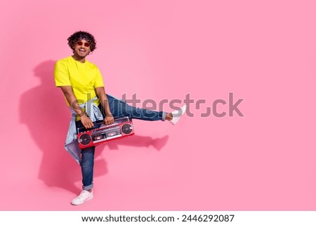 Photo of cheerful positive man wear stylish yellow clothes dance freestyle empty space isolated on pink color background