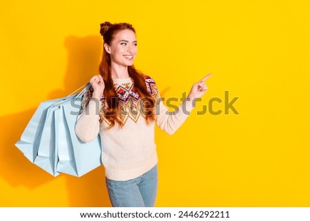 Photo of attractive woman shopping bags point look empty space dressed stylish knitted warm outfit isolated on yellow color background