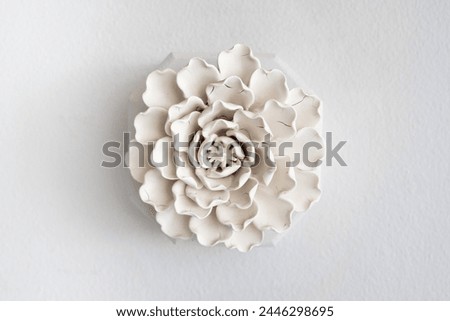 Elegant white ceramic flower sculpture mounted on a wall providing a minimalist and artistic decor element for modern interior