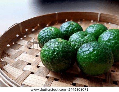 12. Seven green limes (Citrus xamblicarpa), placed on a woven bamboo plate (12) Royalty-Free Stock Photo #2446308091