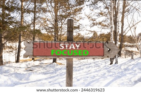 Stay focused symbol. Concept words Stay focused on beautiful wooden road sign. Beautiful forest snow blue sky background. Business, support, motivation, psychological stay focused concept. Copy space