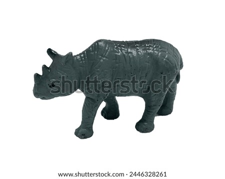 The toy is a gray rhino on a white background. Rubber toy animal rhino. Wild animal toy rhino