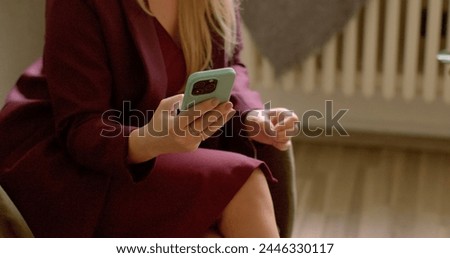 Woman uses mobile phone or smartphone in hands. She reacts to information she receives. Online dating app using lonely person indoor. Woman chatting, talking by video call.