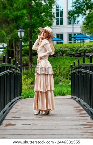 A stunning model showcases fall fashion amidst nature's beauty, exuding elegance and charm in a picturesque park stroll.