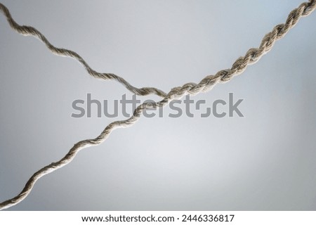 Two strands of yarn are twisted together to form a strong rope, business concept for teamwork, cooperation and partnership, gray background, copy space Royalty-Free Stock Photo #2446336817