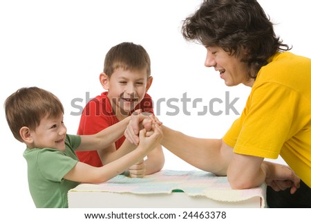  father with two sons in colour clothes is arm wrestling, isolated on white