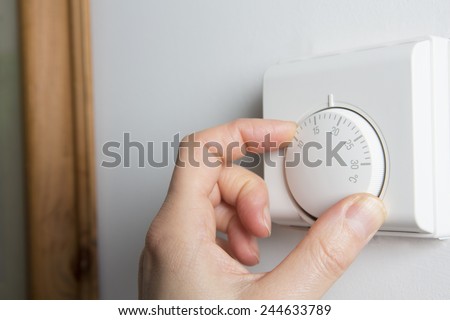 Close Up Of Female Hand On Central Heating Thermostat Royalty-Free Stock Photo #244633789