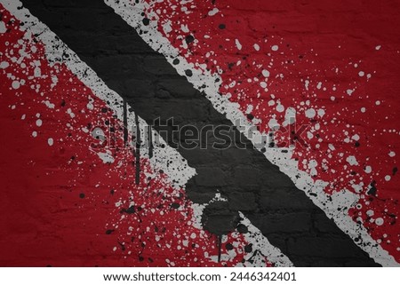 colorful painted big national flag of trinidad and tobago on a massive old brick wall