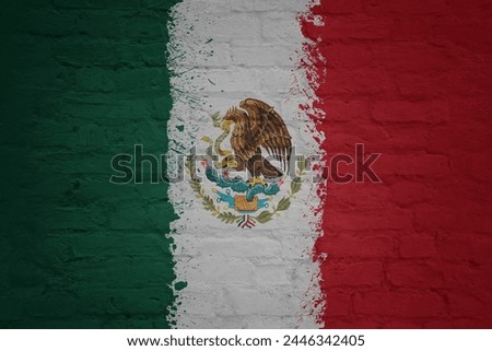 colorful painted big national flag of mexico on a massive old brick wall