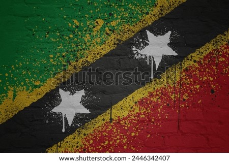 colorful painted big national flag of saint kitts and nevis on a massive old brick wall