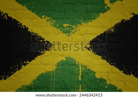 colorful painted big national flag of jamaica on a massive old brick wall