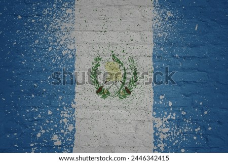 colorful painted big national flag of guatemala on a massive old brick wall