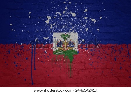 colorful painted big national flag of haiti on a massive old brick wall