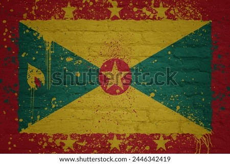 colorful painted big national flag of grenada on a massive old brick wall