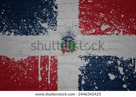 colorful painted big national flag of dominican republic on a massive old brick wall