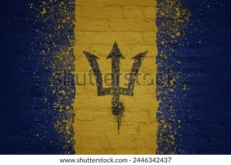 colorful painted big national flag of barbados on a massive old brick wall