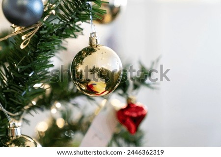 Christmas composition, gold and silver baubles, bows, animals, bells, lit garlands on a festive xmas fir tree against the decorative brick wall background. Copy space. Winter holidays concept.	