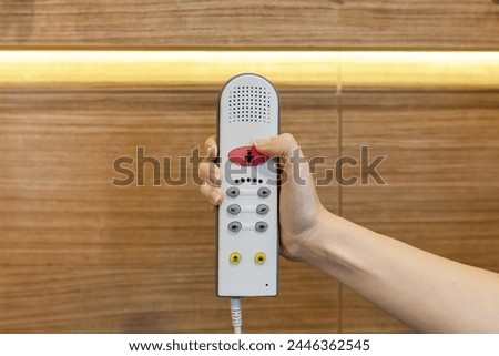 Nurse call button in patient room in modern hospital. Hand pushing nurse call button. patient press red emergency button to calling nurse for help in hospital Royalty-Free Stock Photo #2446362545
