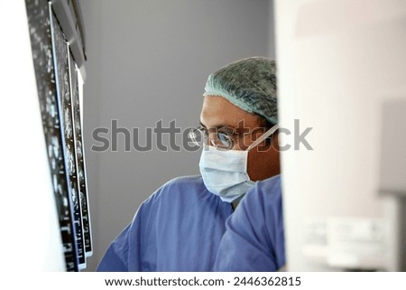 Doctor examining x-ray images in hospital, operating room. x-ray the brain by mri scan or  looking x-ray of the patient's lungs. Royalty-Free Stock Photo #2446362815