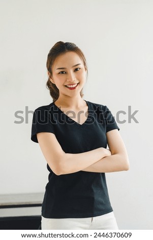 Confident Young Asian Woman Smiling with Arms Crossed