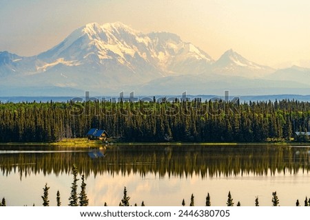 Twilight Tranquility: Cabin on the Alaskan Lake Royalty-Free Stock Photo #2446380705