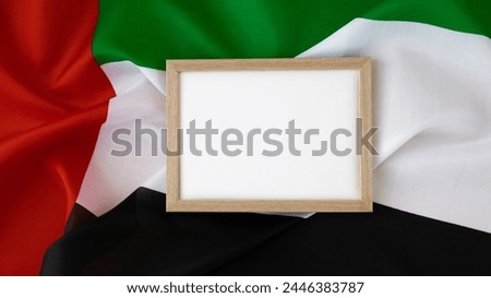 Empty white paper frame template National symbol of UAE. United Arab Emirates small flag with Peregrine falcon on neutral beige background. Copy space for your text. Concept of Independence  Royalty-Free Stock Photo #2446383787