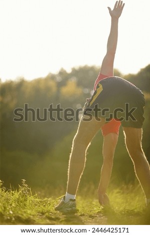 Man, stretching and sunshine in outdoor for exercise with fitness motivation, legs and sports activity. Male person, training and nature with grass for wellness, strong body and health workout Royalty-Free Stock Photo #2446425171