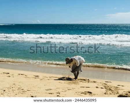 boy running happily on the beach during a bright blue sky during the day