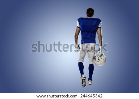 Football Player with a blue uniform walking, showing his back on a blue background.
