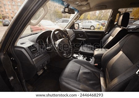 Leather black seats in the car interior on the front row for the passenger and driver. Royalty-Free Stock Photo #2446468293
