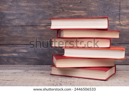 Composition with hardback books, fanned pages on wooden deck table and background. Books stacking. Back to school. Copy Space. Education background