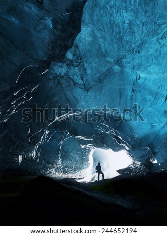 Man exploring an amazing glacial cave in Iceland Royalty-Free Stock Photo #244652194