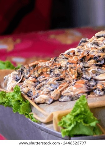 a photography of a pizza with mushrooms and lettuce on a wooden board. Royalty-Free Stock Photo #2446523797