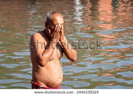 devotee praying after bathing in holy river water at morning from flat angle Royalty-Free Stock Photo #2446530269