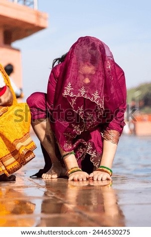 young devotee praying for holy god after bathing in holy river water at morning from flat angle Royalty-Free Stock Photo #2446530275