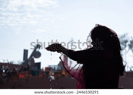 backlit shot of young devotee praying for holy god after bathing in holy river water at morning Royalty-Free Stock Photo #2446530291
