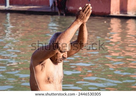 devotee praying after bathing in holy river water at morning from flat angle Royalty-Free Stock Photo #2446530305